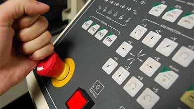 Shot of an operator pushing the emergency stop button on a machine