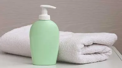 Lotion bottle on table with bath towel