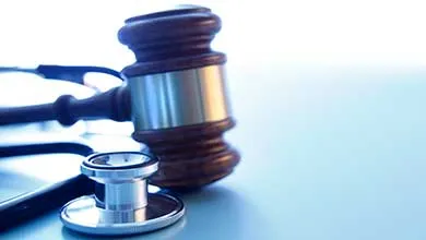 A gavel and a stethoscope on a blue background representing the intersection of the medical and legal industries.