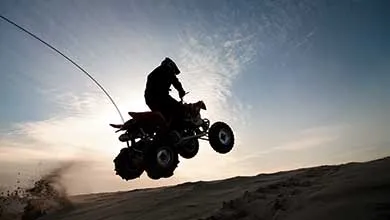 Silhouette of a person jumping quadbike