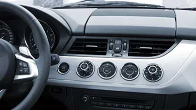 Modern car interior: black and silver dashboard, center console, automatic gear shift.