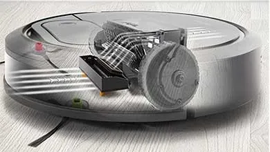 Cutaway illustration of a gray robot vacuum, showing the internal roller brush, wheel, and airflow directing dirt into the dustbin.