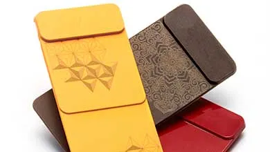 Three decorative folders—yellow, dark brown, and red—are fanned out. The yellow folder has an embossed geometric pattern, and the brown folder features an intricate mandala design.